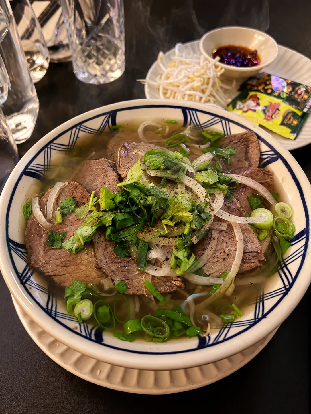 A bowl of beef pho with herbs at Saigon Sister Riccarton